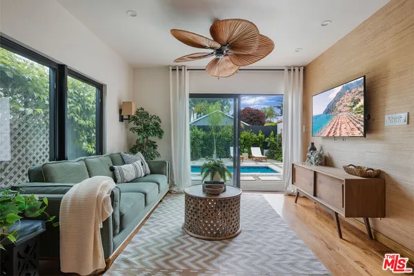 a living room with furniture potted plant and a large window