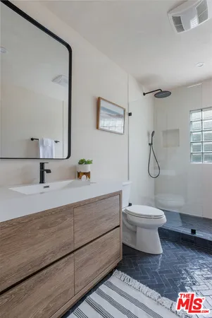 a bathroom with a white toilet sink and shower
