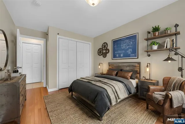 a bedroom with a bed a painting on the wall and a dresser
