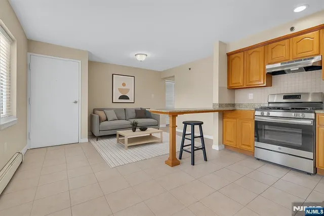 a living room with furniture a flat screen tv and kitchen view