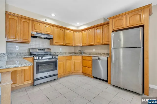 a kitchen with a refrigerator sink and cabinets