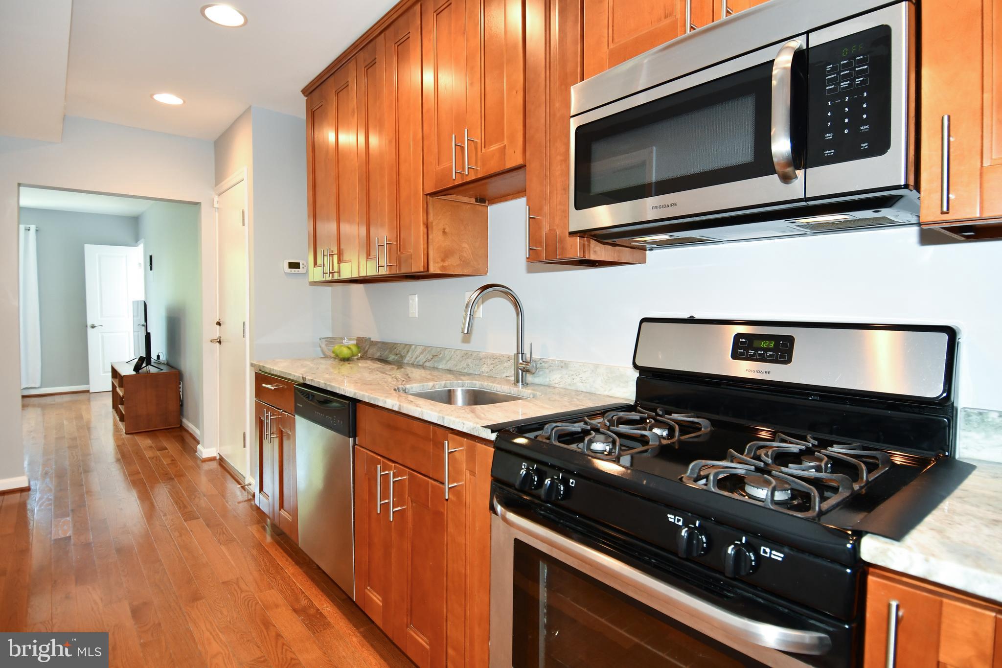 1643 Montello Avenue Northeast, Unit 4 Washington, DC 20002 - Photo 11 of 30 a kitchen with a stove and a microwave