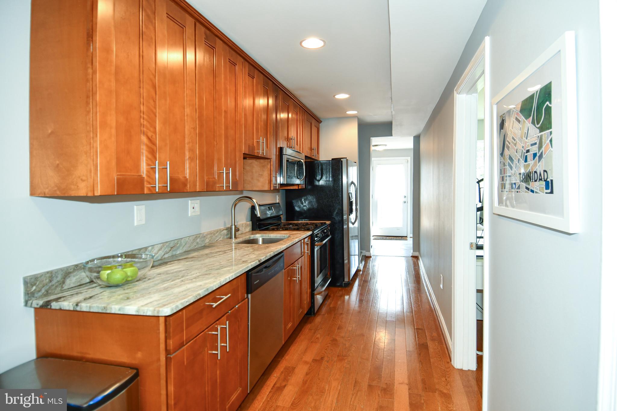 1643 Montello Avenue Northeast, Unit 4 Washington, DC 20002 - Photo 10 of 30 a kitchen with stainless steel appliances granite countertop a sink a stove and a refrigerator