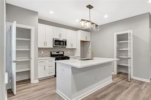 6814 Dumble Street, Unit B Houston, TX 77021 - Photo 5 of 22 a kitchen with kitchen island granite countertop stainless steel appliances a stove a sink and a refrigerator