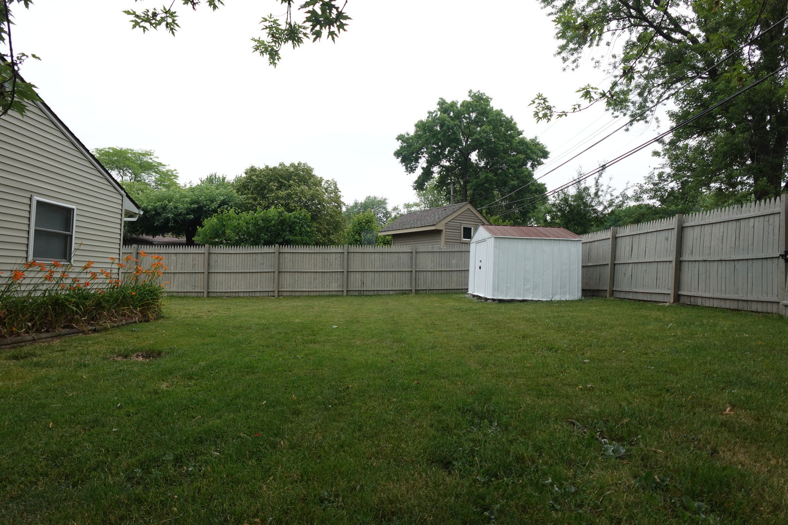 613 South Oltendorf Road Streamwood, IL 60107 - Photo 3 of 37 a view of a backyard with grass and wooden fence