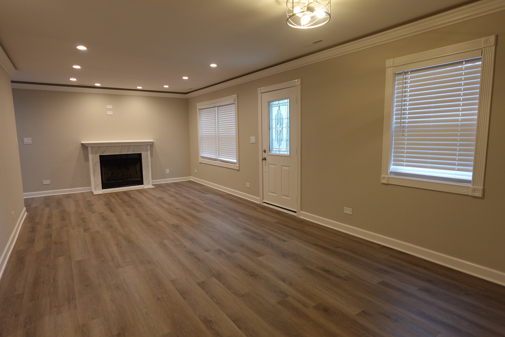 613 South Oltendorf Road Streamwood, IL 60107 - Photo 5 of 37 a view of an empty room with wooden floor fireplace and a window