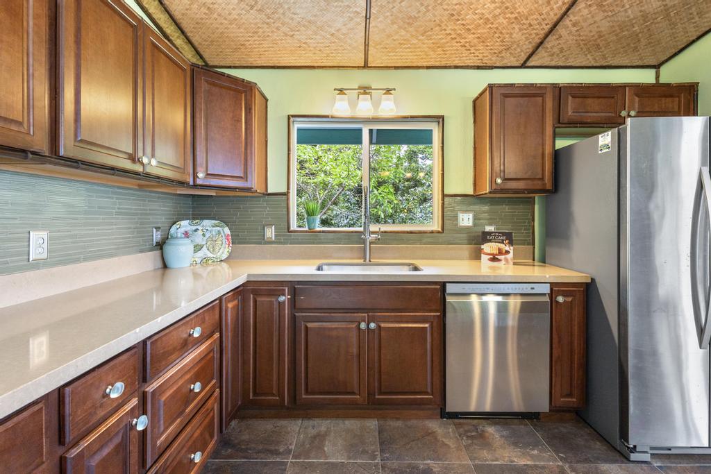 87-2707 Hawaii Belt Road Captain Cook, HI 96704 - Photo 16 of 30 a kitchen with stainless steel appliances granite countertop a sink and a refrigerator