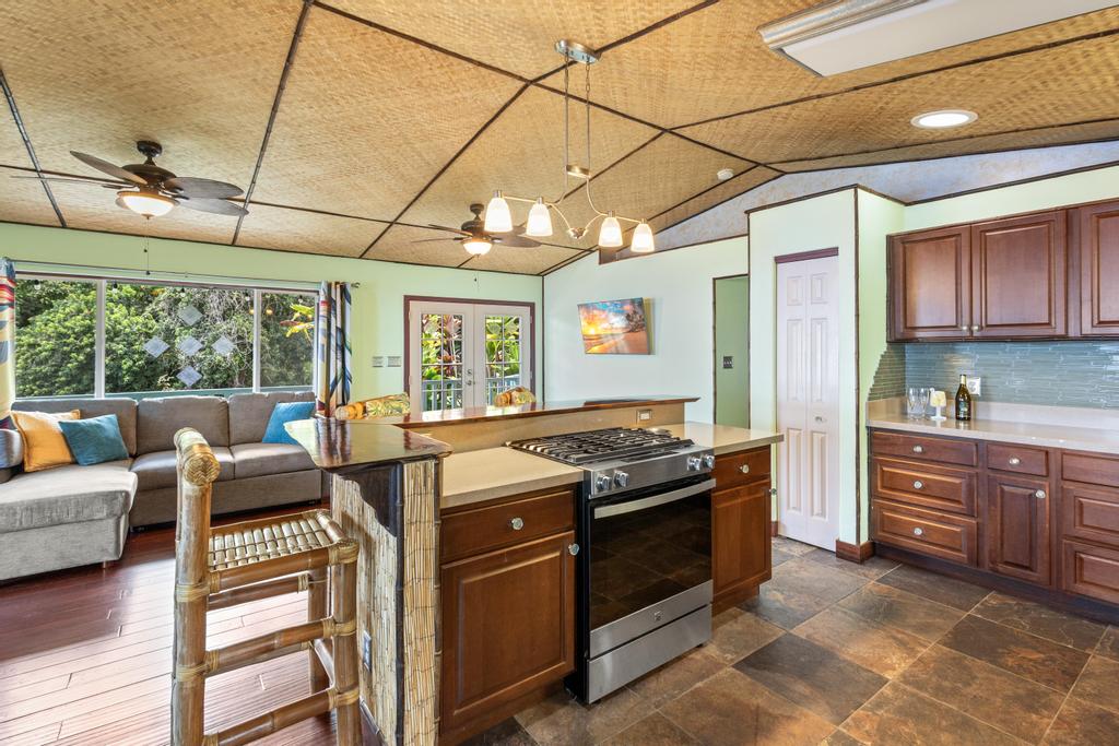 87-2707 Hawaii Belt Road Captain Cook, HI 96704 - Photo 17 of 30 a kitchen with stainless steel appliances granite countertop a stove and cabinets