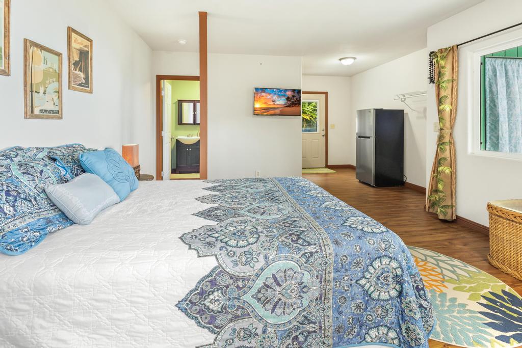 87-2707 Hawaii Belt Road Captain Cook, HI 96704 - Photo 25 of 30 a bedroom with a large bed and a chandelier