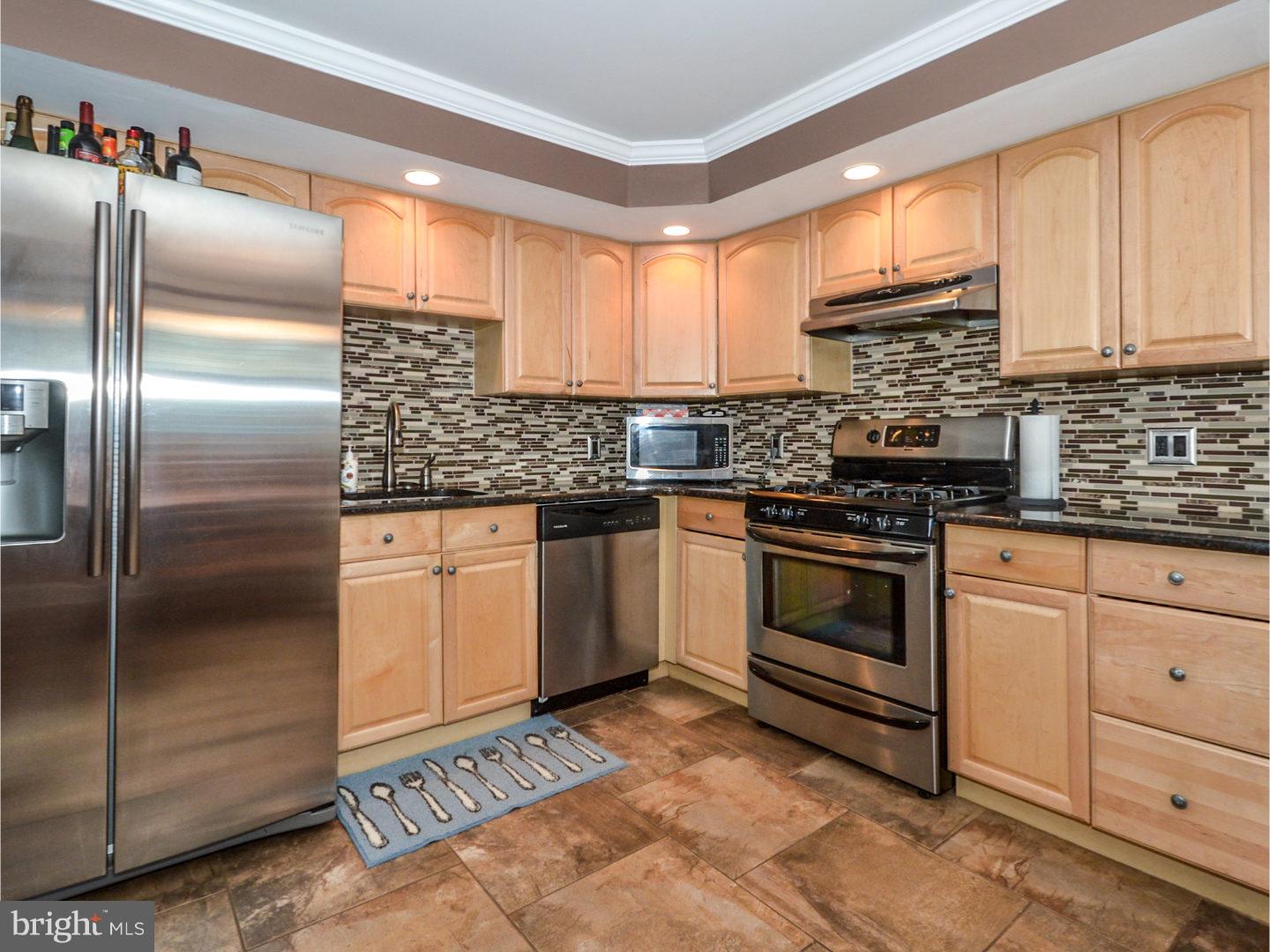 9734 Beacon Road Philadelphia, PA 19115 - Photo 11 of 25 a kitchen with stainless steel appliances granite countertop a stove a sink and a refrigerator