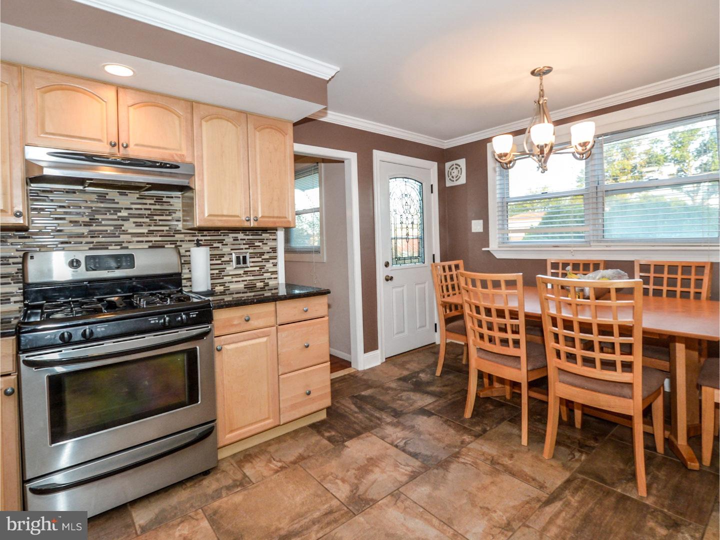 9734 Beacon Road Philadelphia, PA 19115 - Photo 12 of 25 a kitchen with stainless steel appliances a stove a sink refrigerator dining table and chairs