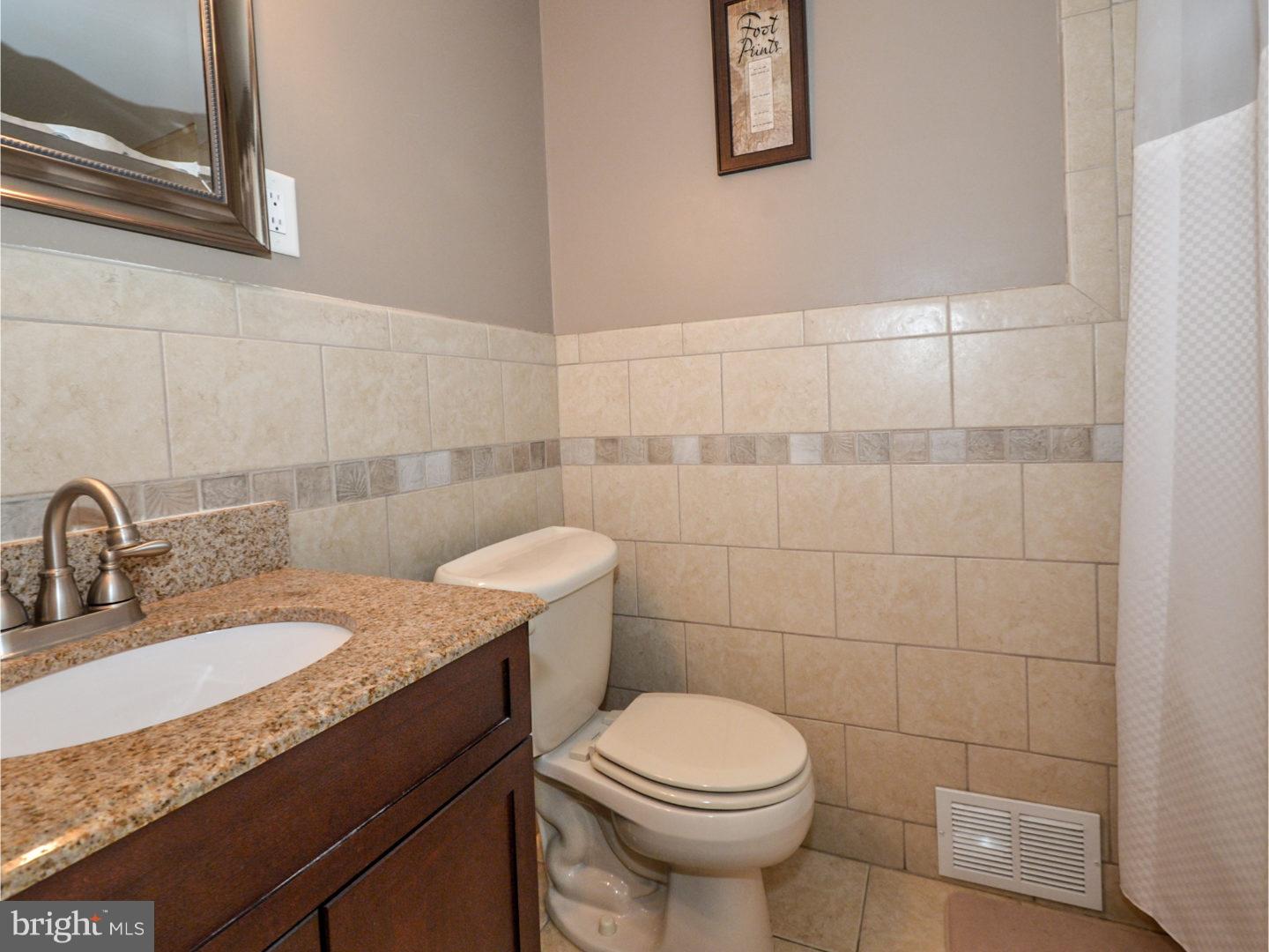 9734 Beacon Road Philadelphia, PA 19115 - Photo 19 of 25 a bathroom with a granite countertop sink a toilet and a mirror