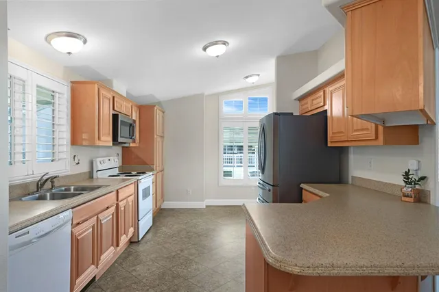 a kitchen with stainless steel appliances granite countertop a sink a stove and a refrigerator