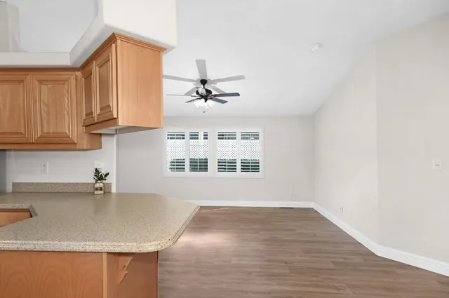 a kitchen with granite countertop a sink a window and cabinets