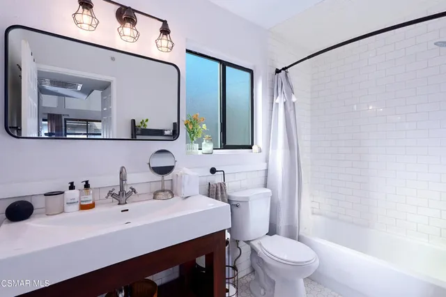 a bathroom with a sink a toilet and shower curtain