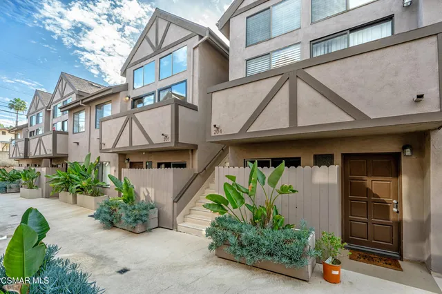 a front view of a house with potted plants