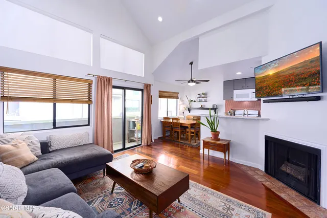 a living room with furniture a flat screen tv and a fireplace