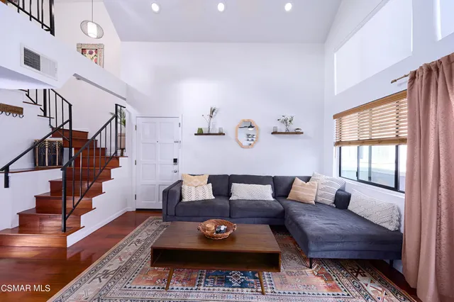 a living room with furniture wooden floor and a window