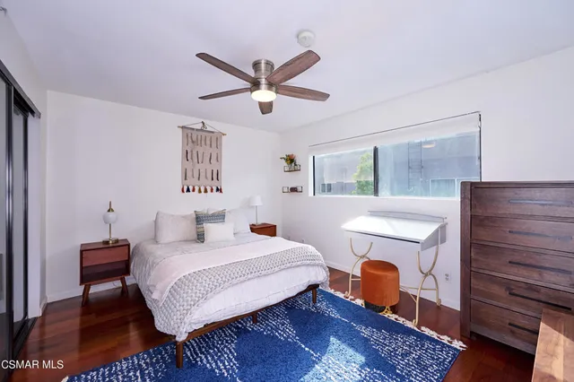 a bedroom with a bed wooden floor and window