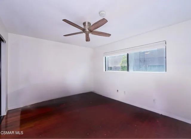 a view of a big room with wooden floor and a ceiling fan