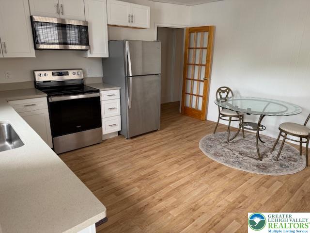 326 Main Street, Unit 1 Emmaus, PA 18049 - Photo 2 of 5 a kitchen with kitchen island a stove a sink and a refrigerator