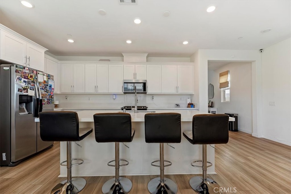 20911 Jennings Way Newhall, CA 91321 - Photo 12 of 47 a kitchen with stainless steel appliances kitchen island granite countertop a dining table chairs and a refrigerator