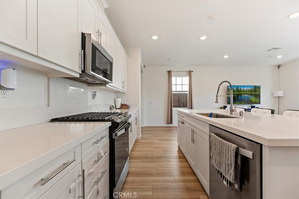 20911 Jennings Way Newhall, CA 91321 - Photo 14 of 47 a kitchen with stainless steel appliances granite countertop a sink and stove top oven