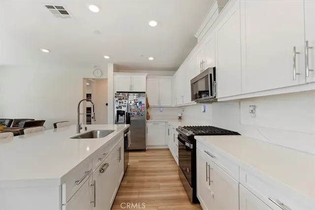 a kitchen with a table chairs microwave and cabinets