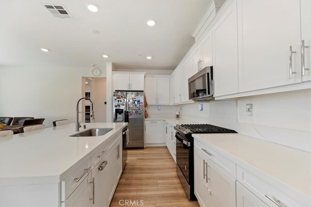 20911 Jennings Way Newhall, CA 91321 - Photo 10 of 47 a kitchen with kitchen island a sink stove and refrigerator