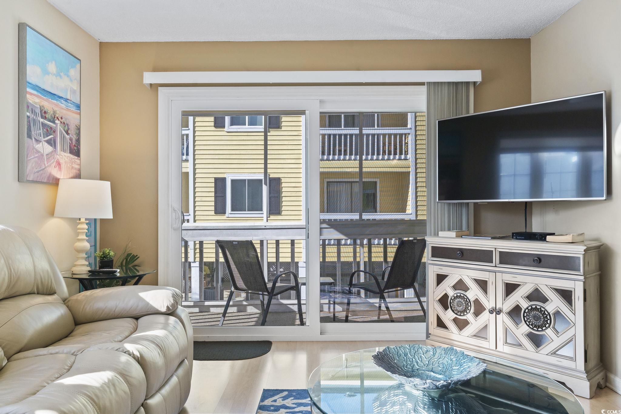 1425 North Waccamaw Drive, Unit 123 Murrells Inlet, SC 29576 - Photo 9 of 39 Living room with plenty of natural light and wood finished floors