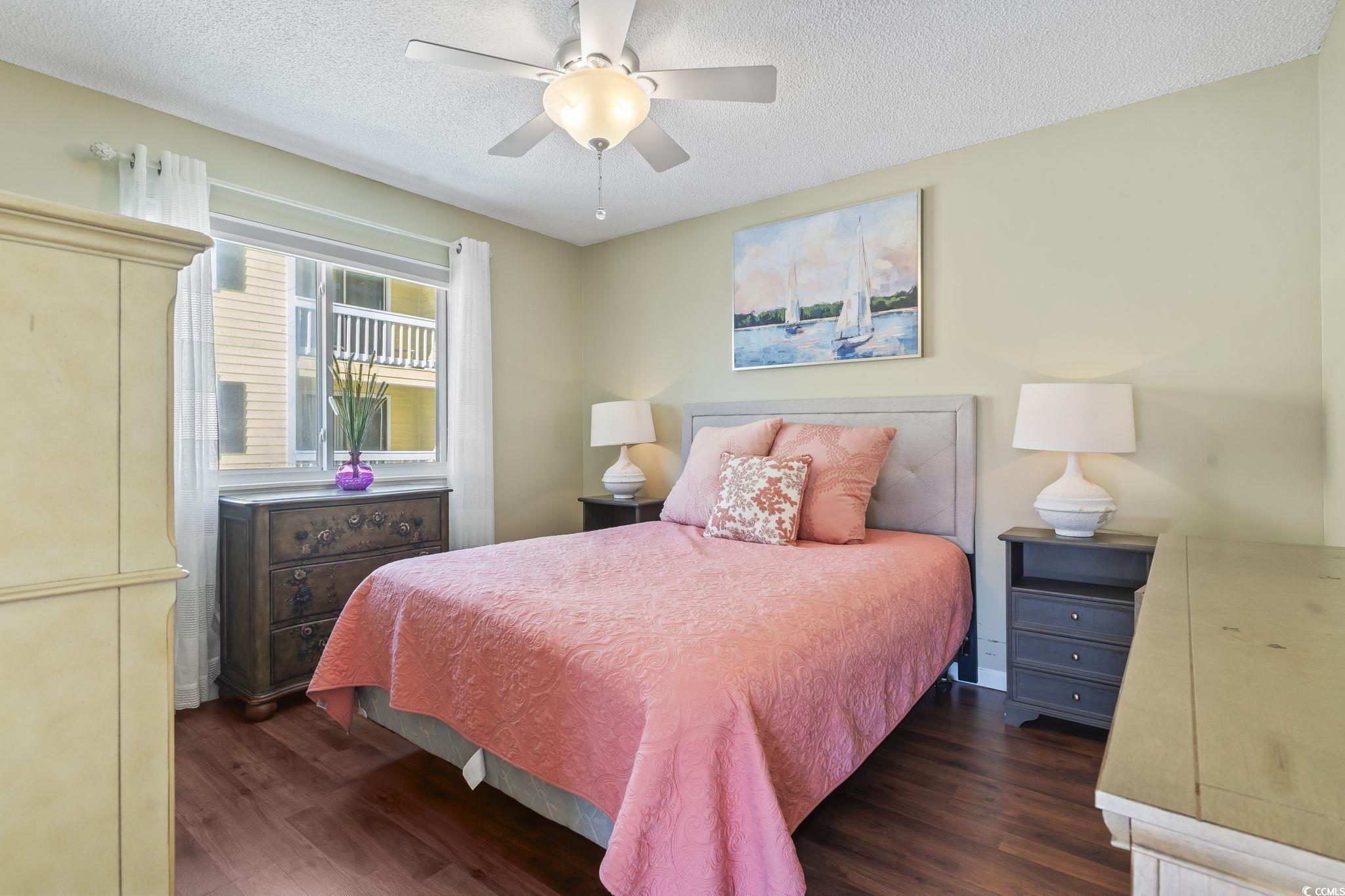 1425 North Waccamaw Drive, Unit 123 Murrells Inlet, SC 29576 - Photo 14 of 39 Bedroom featuring dark wood-style flooring, a textured ceiling, and a ceiling fan