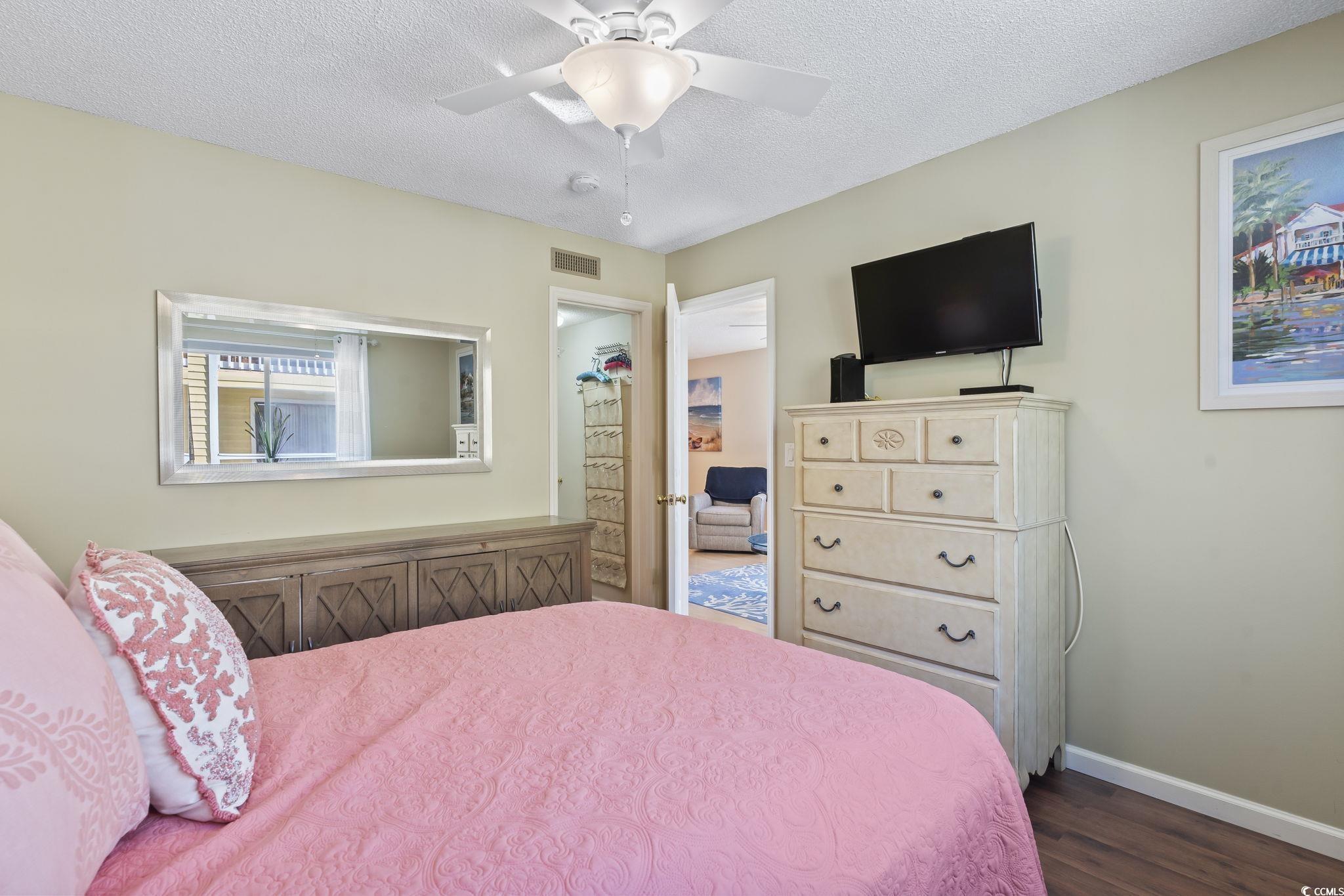 1425 North Waccamaw Drive, Unit 123 Murrells Inlet, SC 29576 - Photo 16 of 39 Bedroom with a textured ceiling, dark wood-style floors, and a ceiling fan