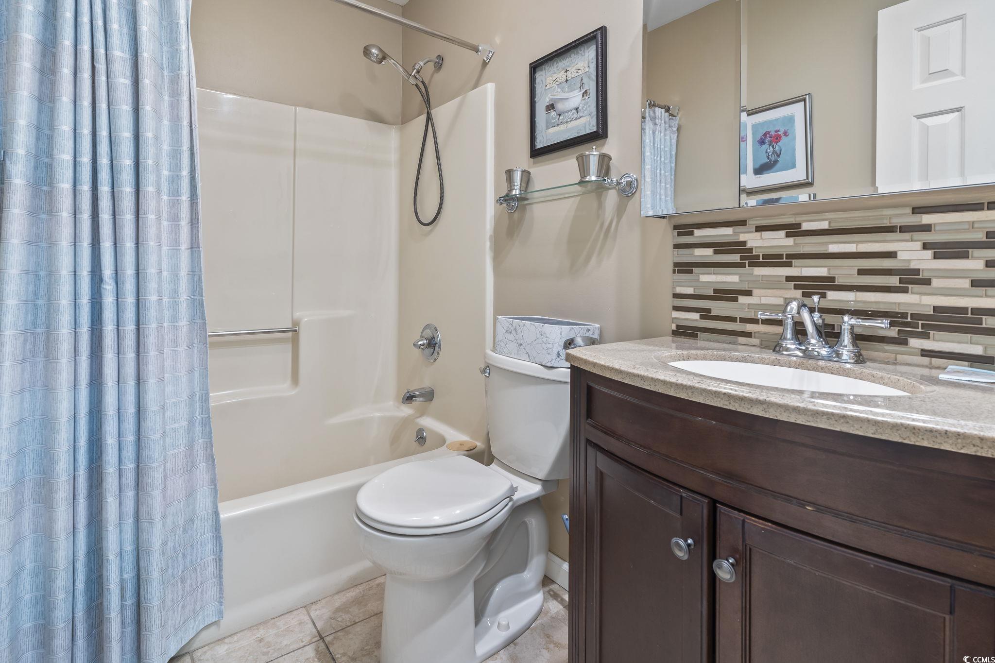 1425 North Waccamaw Drive, Unit 123 Murrells Inlet, SC 29576 - Photo 18 of 39 Full bath featuring backsplash, vanity, shower / bath combination with curtain, and tile patterned flooring