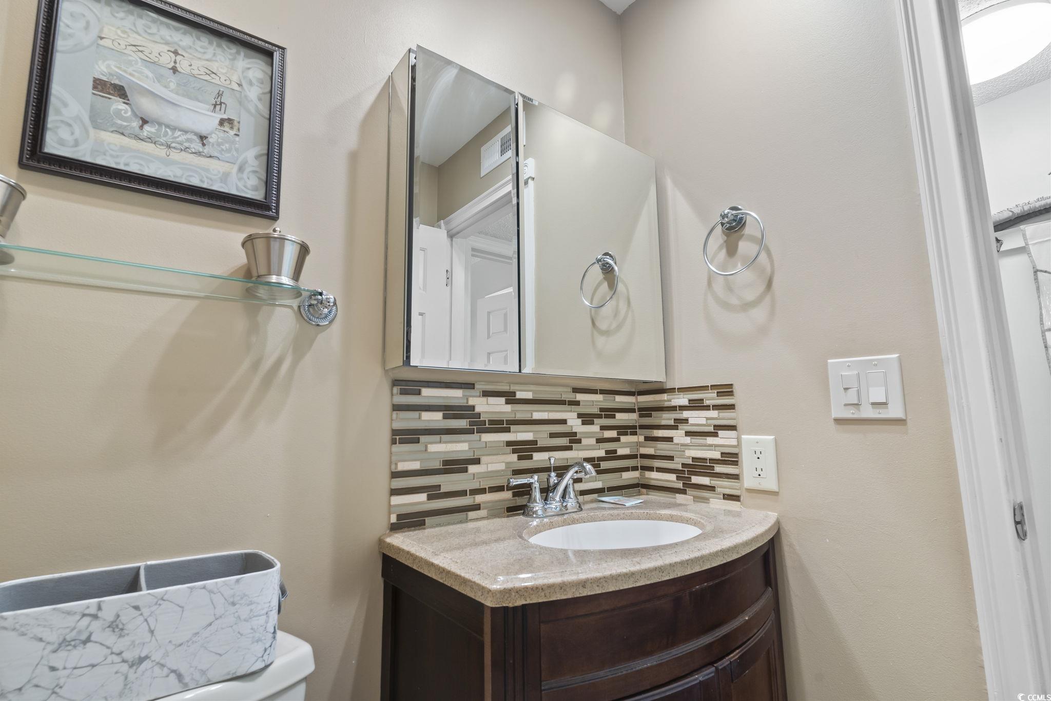 1425 North Waccamaw Drive, Unit 123 Murrells Inlet, SC 29576 - Photo 19 of 39 Half bathroom featuring tasteful backsplash and vanity