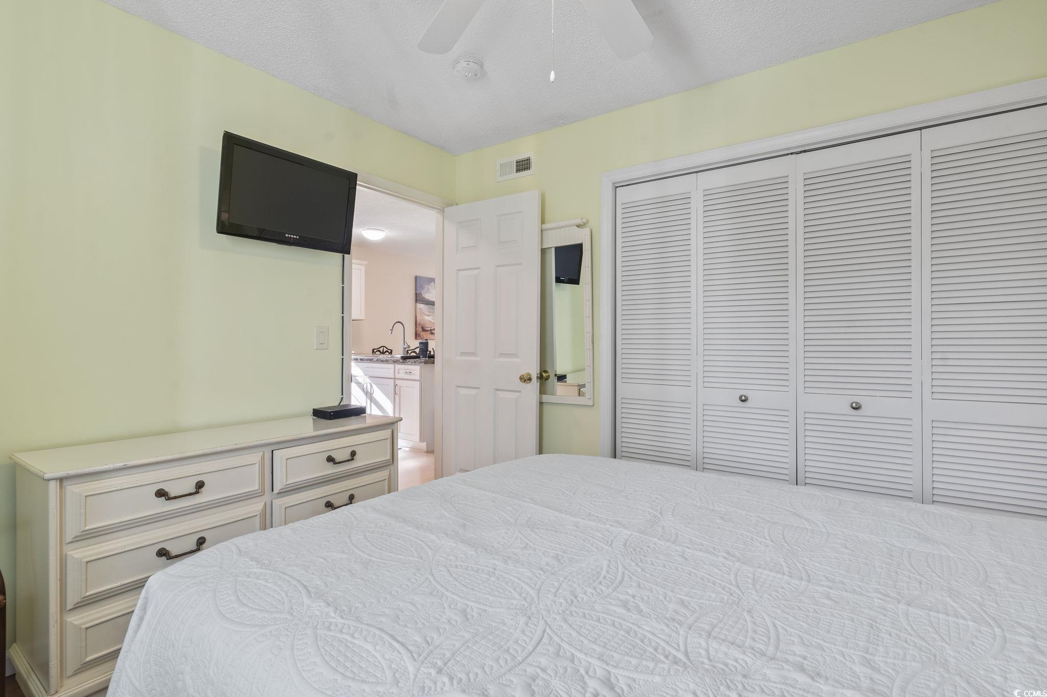 1425 North Waccamaw Drive, Unit 123 Murrells Inlet, SC 29576 - Photo 21 of 39 Bedroom featuring a closet, a textured ceiling, and a ceiling fan