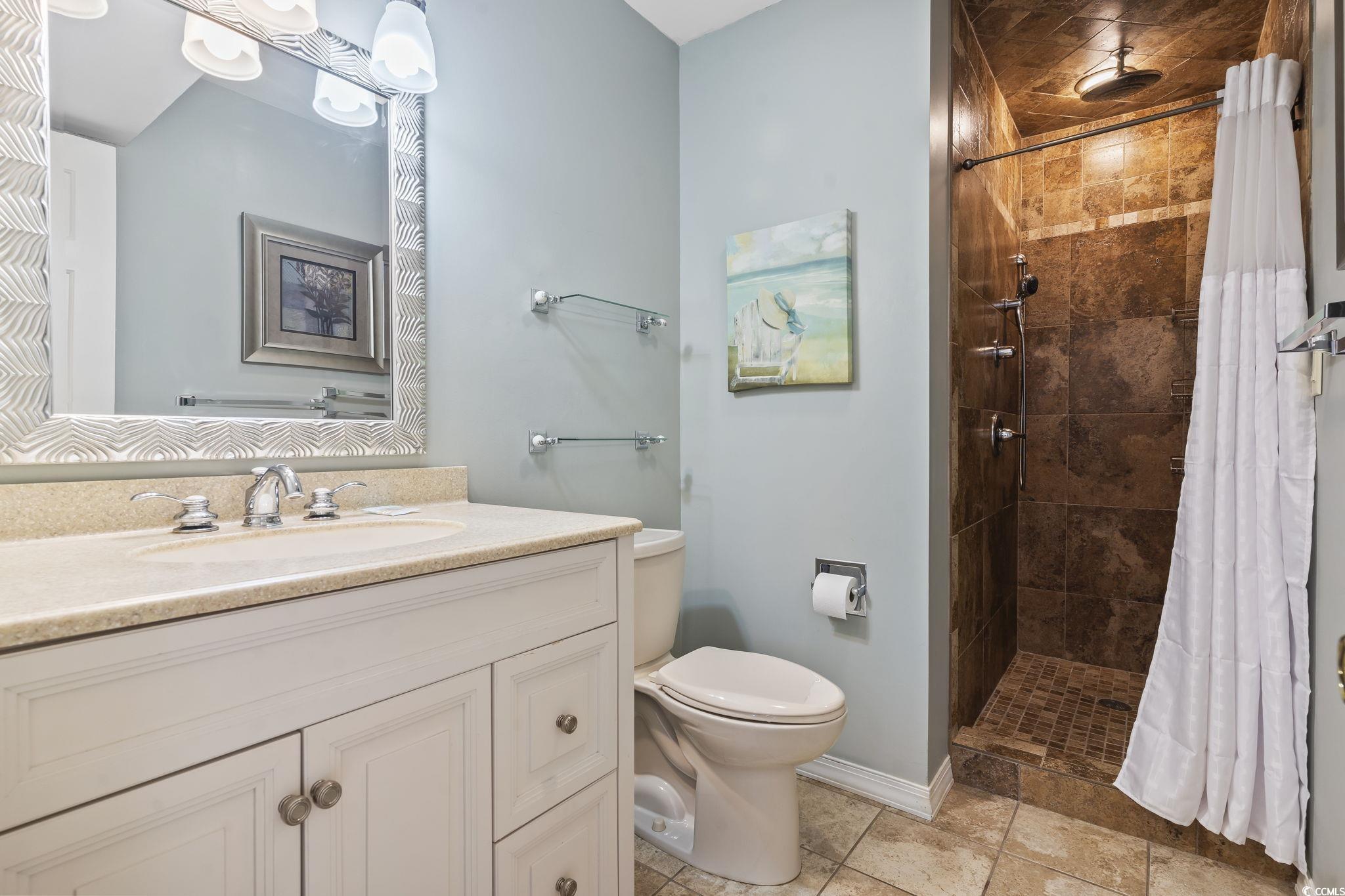 1425 North Waccamaw Drive, Unit 123 Murrells Inlet, SC 29576 - Photo 24 of 39 Full bathroom with vanity, tiled shower, and tile patterned flooring