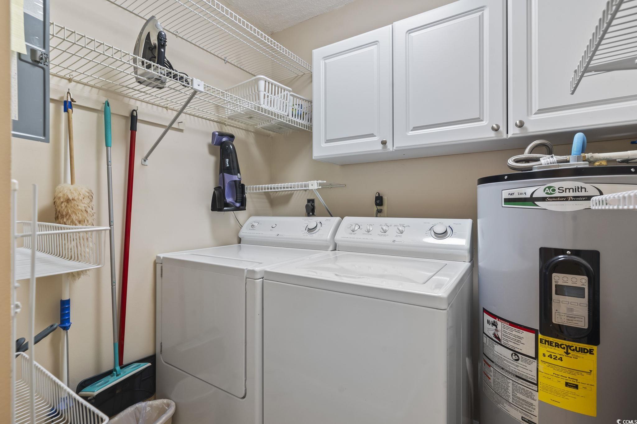 1425 North Waccamaw Drive, Unit 123 Murrells Inlet, SC 29576 - Photo 34 of 39 Washroom with water heater, washing machine and dryer, and cabinet space