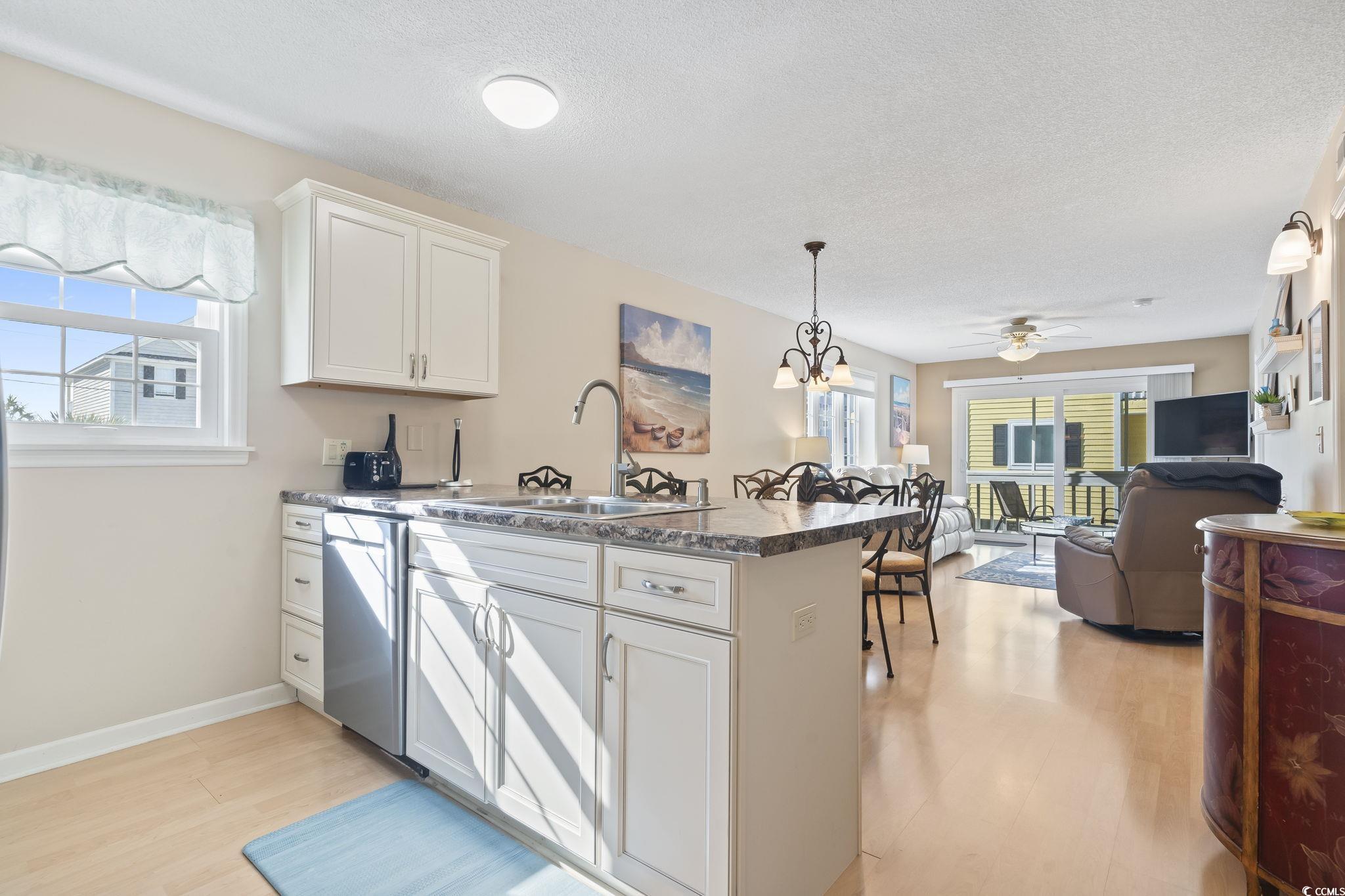1425 North Waccamaw Drive, Unit 123 Murrells Inlet, SC 29576 - Photo 39 of 39 Kitchen featuring a chandelier, a peninsula, light wood-style flooring, open floor plan, and white cabinetry