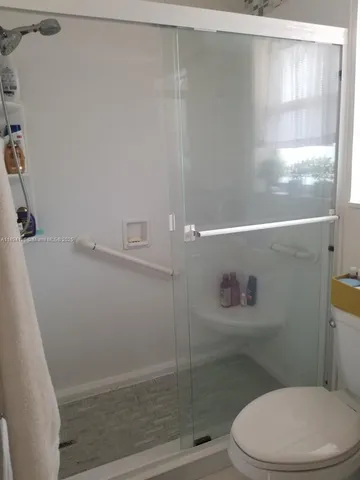 a bathroom with a toilet and a shower