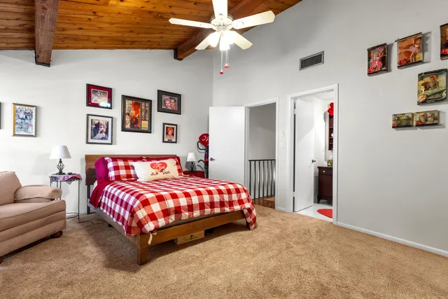 a bedroom with a bed couch and ceiling fan