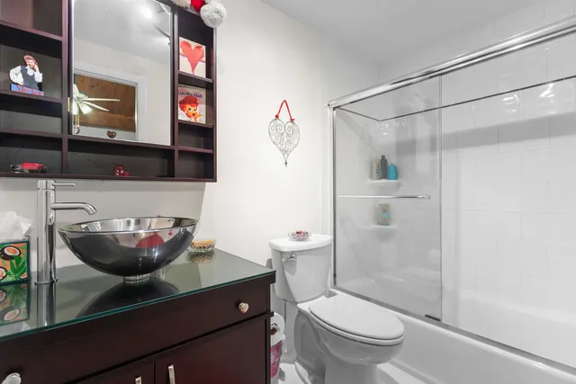 a bathroom with a granite countertop sink a toilet and shower