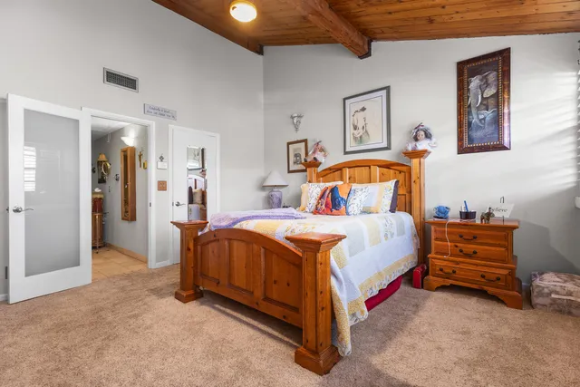 a spacious bedroom with a bed and a lamp