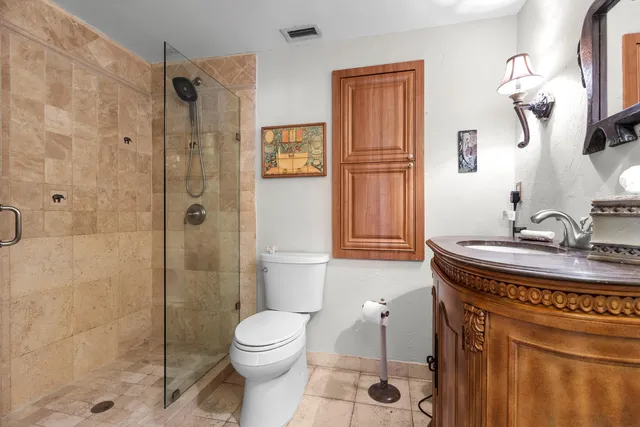 a bathroom with a granite countertop sink toilet and shower