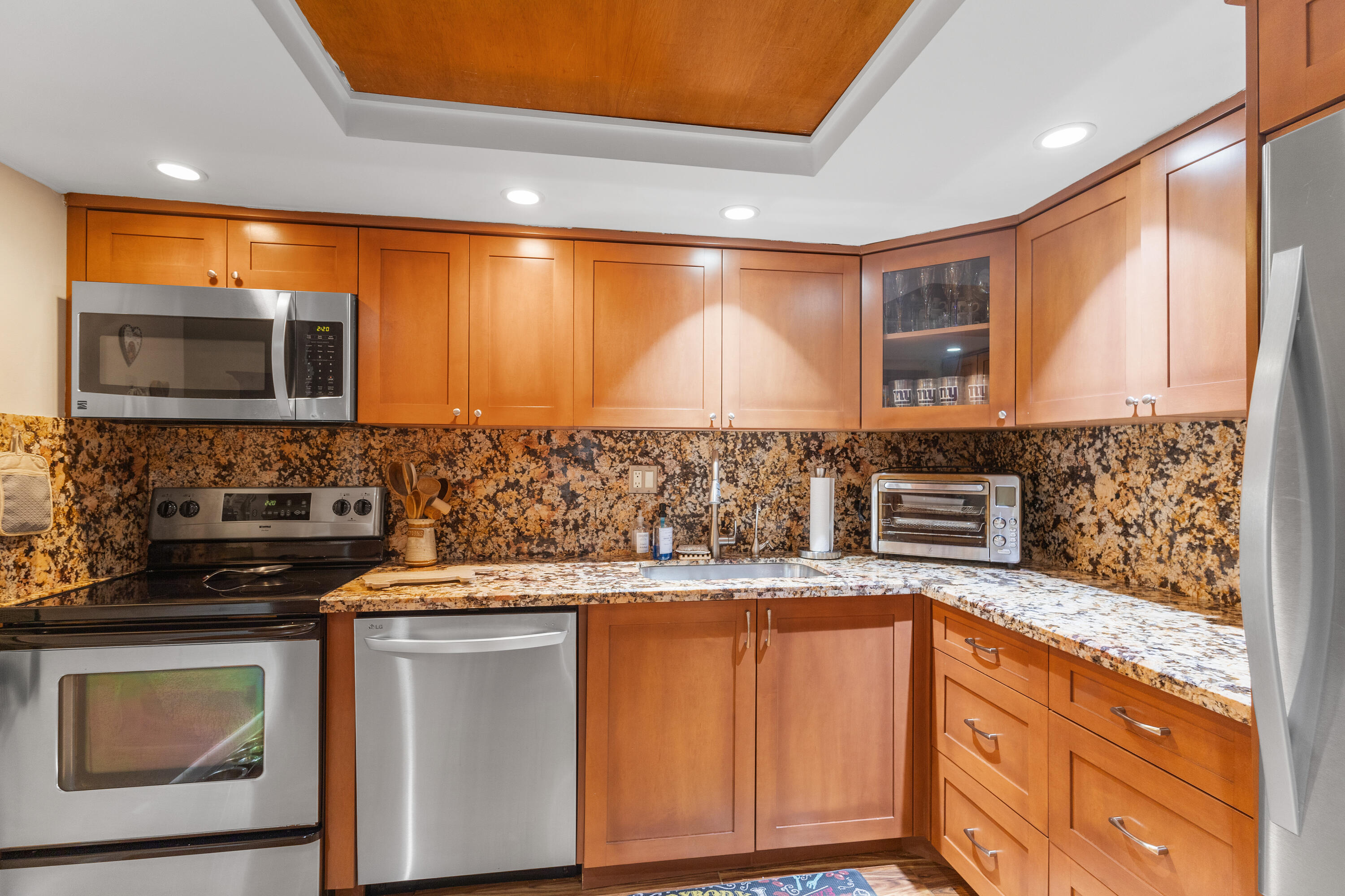 4601 Northwest 2nd Avenue, Unit 811 Boca Raton, FL 33431 - Photo 5 of 30 a kitchen with granite countertop a stove top oven microwave and cabinets