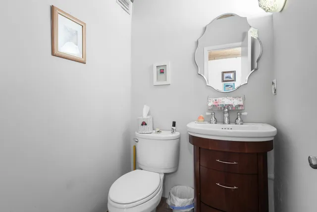 a bathroom with a toilet a sink and mirror