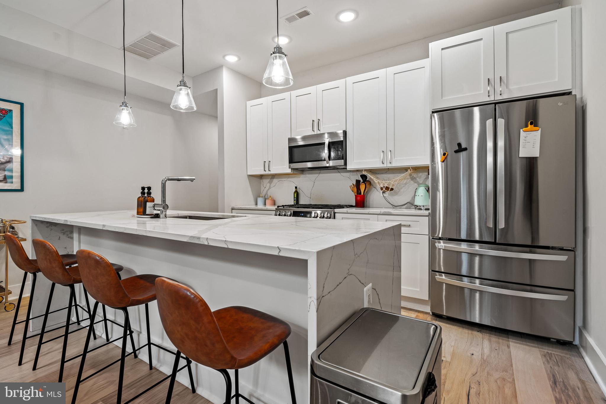 a kitchen with stainless steel appliances a stove a sink island and a refrigerator