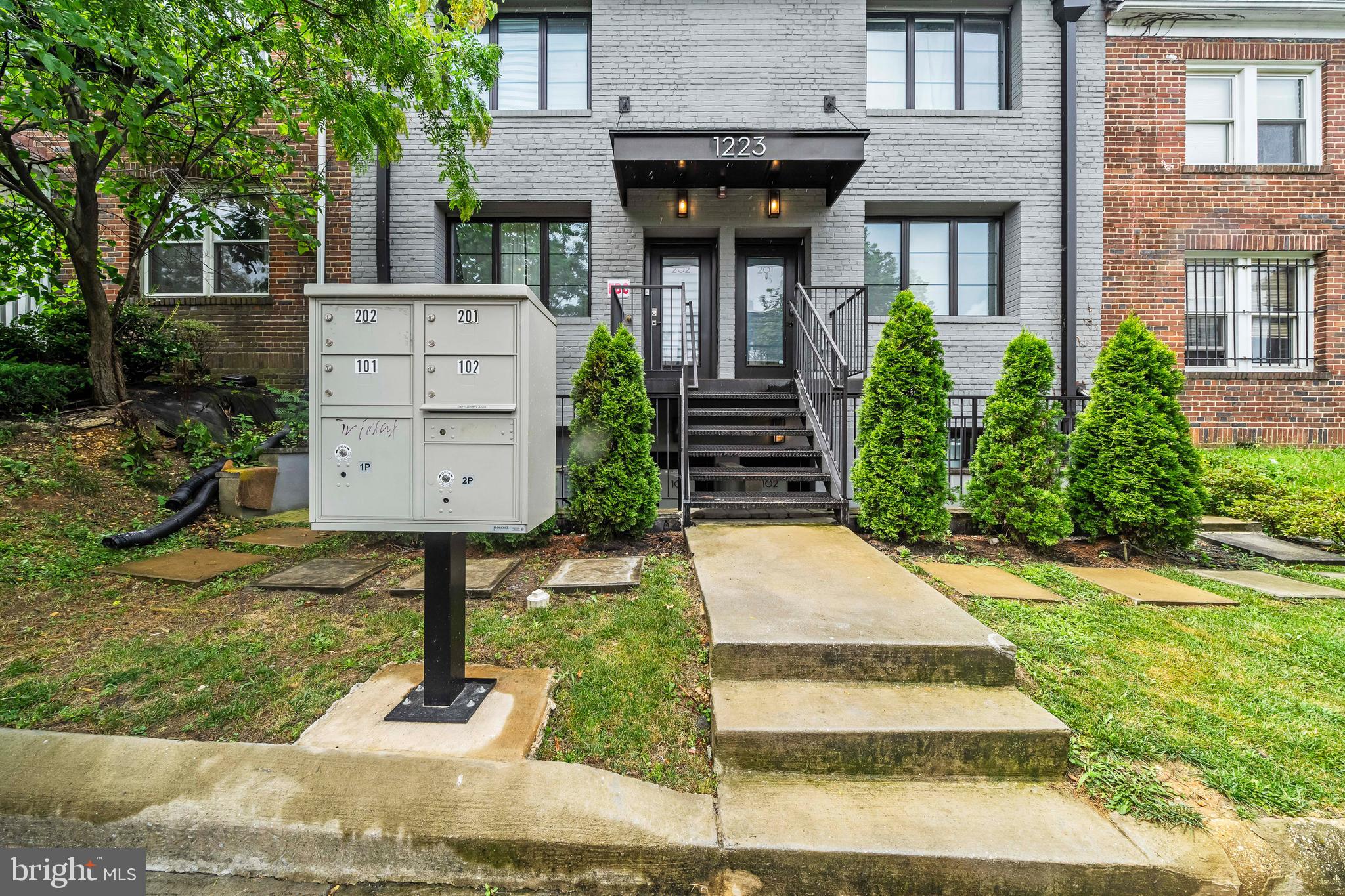 1223 Meigs Place Northeast, Unit 101 Washington, DC 20002 - Photo 2 of 22 a front view of a house with garden