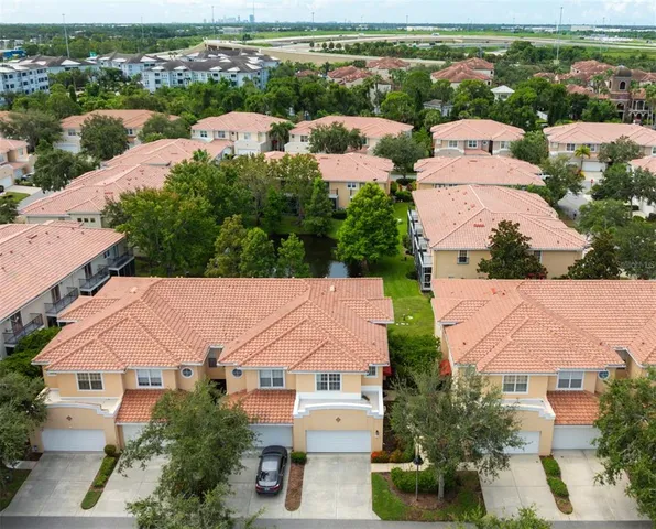 an aerial view of residential houses with outdoor space and trees