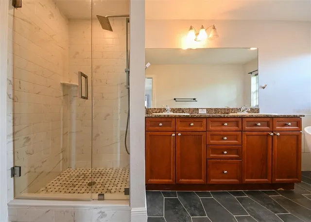 a spacious bathroom with a double vanity sink tub and a mirror
