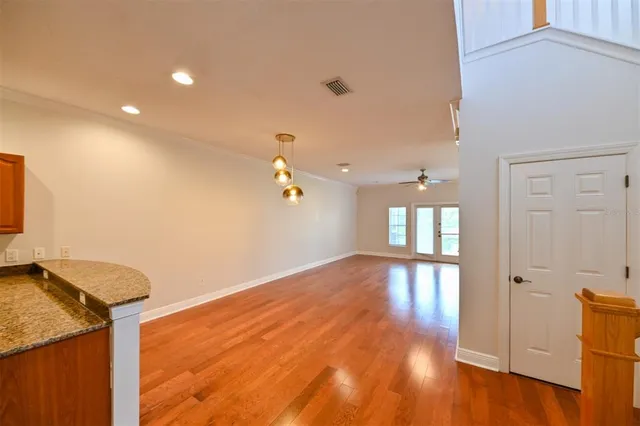 a view of an empty room and kitchen view